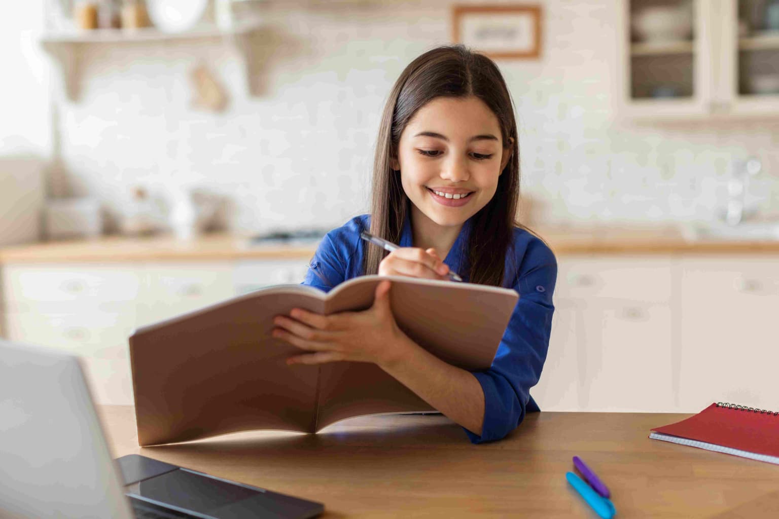 school-girl-writing-in-textbook-near-computer-stud-2023-11-27-05-23-30-utc-compressed