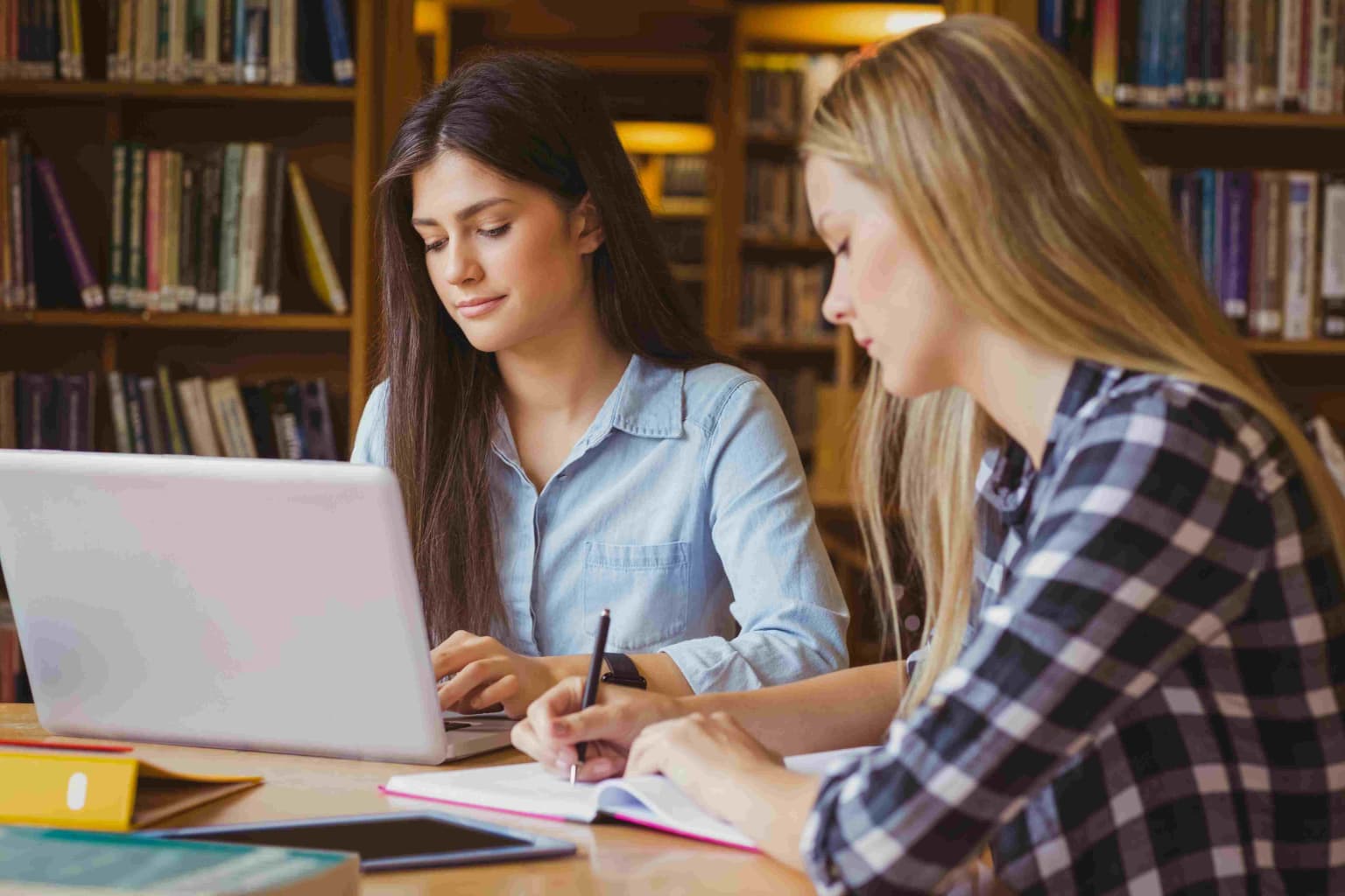 smiling-students-using-laptop-in-library-2023-11-27-05-30-49-utc-compressed