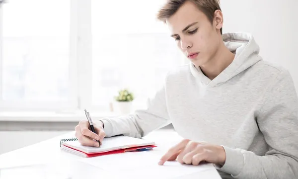 Lycéen révisant dans sa chambre sa spécialité LLCA au bac